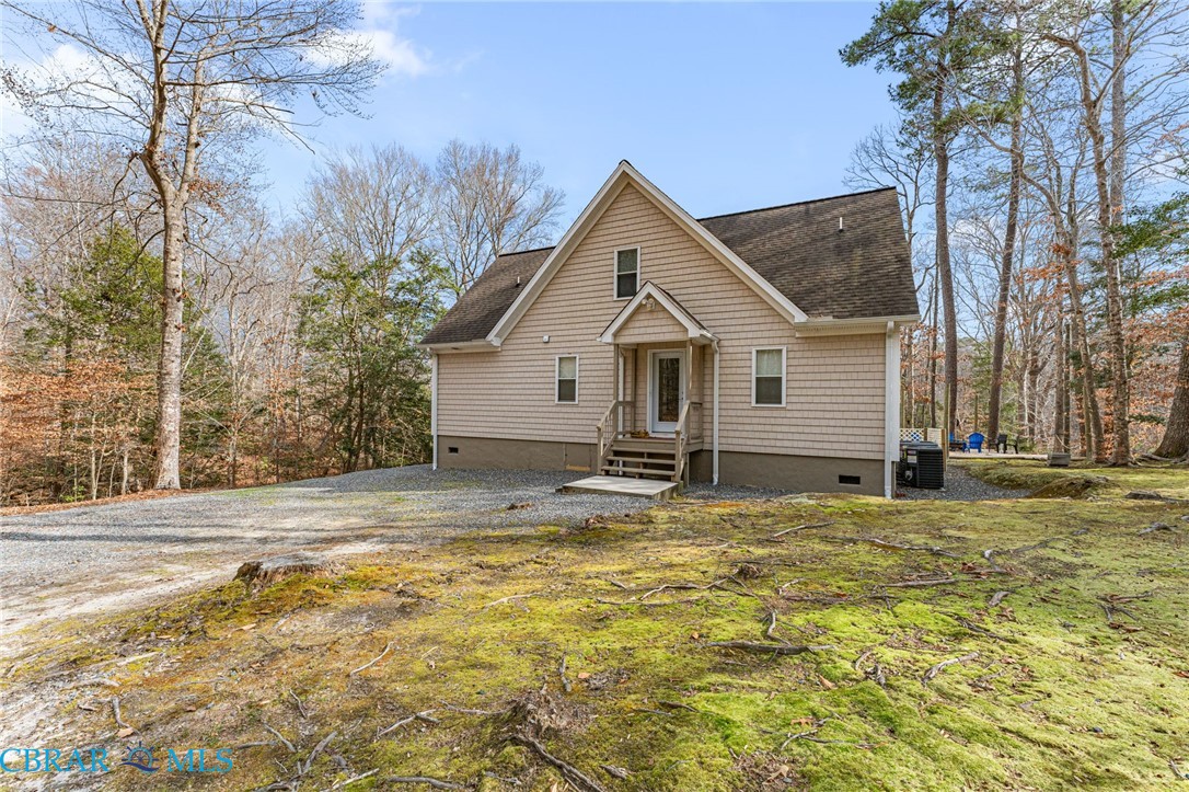 4775 Stormont Road Hartfield, VA 23071 - Photo 16 of 45 View of front facade with crawl space, a shingled roof, and view of wooded area