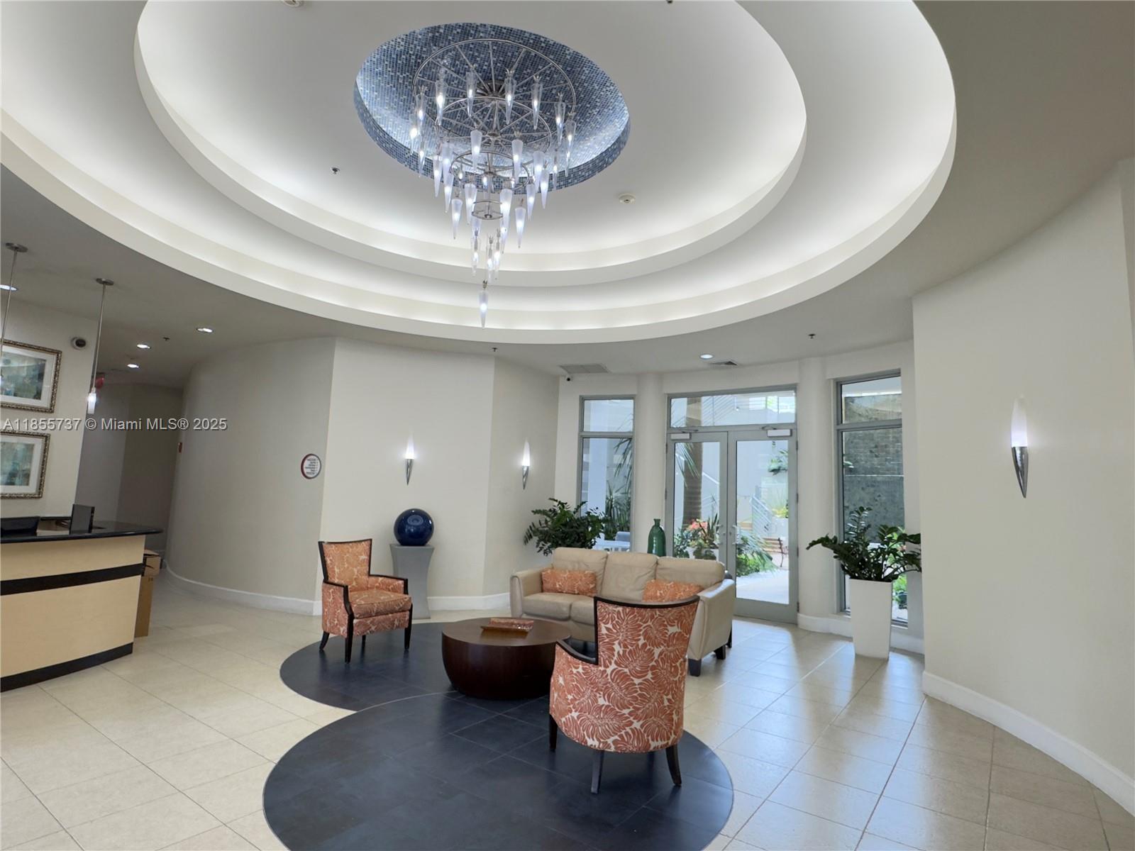 1830 Radius Drive, Unit 1301 Hollywood, FL 33020 - Photo 11 of 41 a living room with furniture and a chandelier