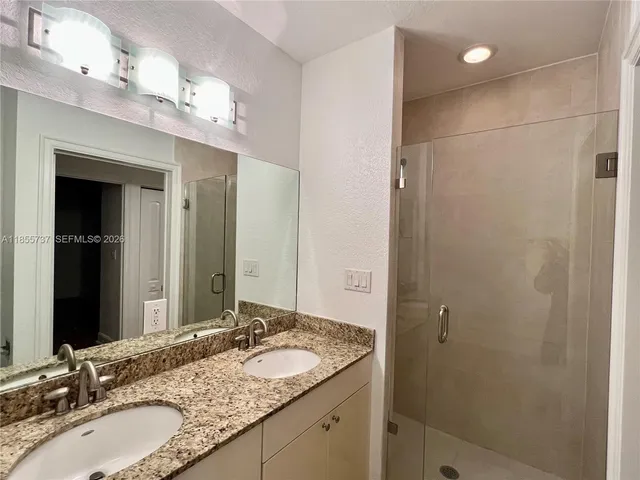 a bathroom with a granite countertop sink and toilet