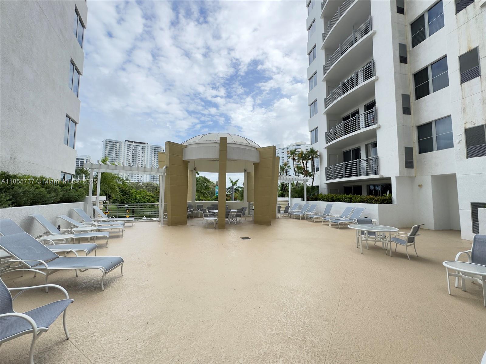 1830 Radius Drive, Unit 1301 Hollywood, FL 33020 - Photo 18 of 41 a view of a patio with a table and chairs under an umbrella