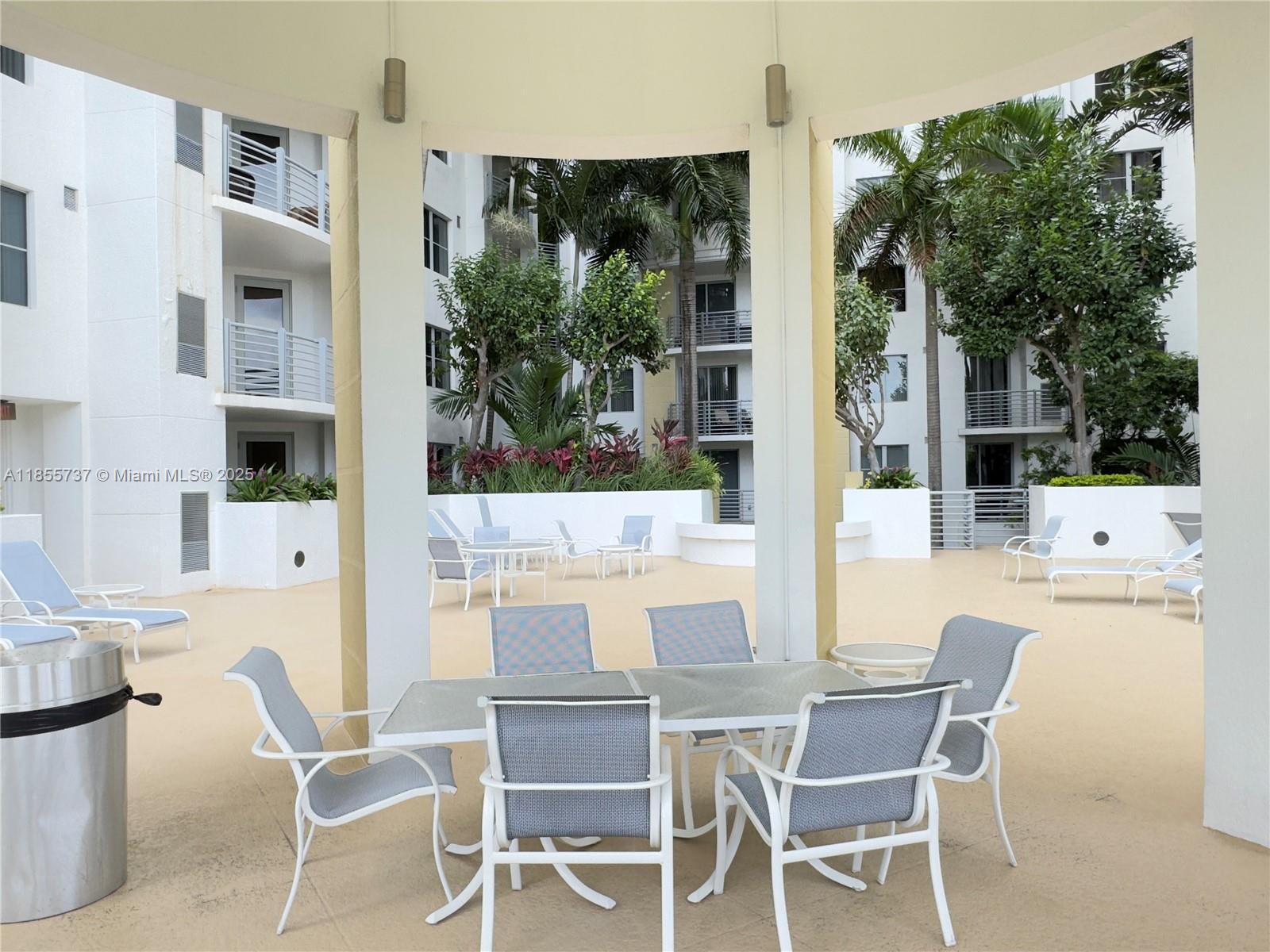 1830 Radius Drive, Unit 1301 Hollywood, FL 33020 - Photo 19 of 41 a view of a patio with table and chairs and potted plants