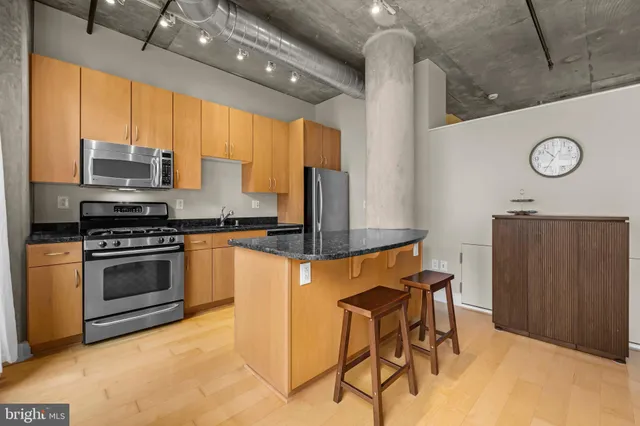 a kitchen with stainless steel appliances a stove a refrigerator and a dining table