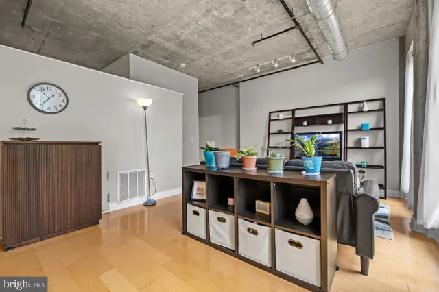 a living room with stainless steel appliances kitchen island a table and chairs in it