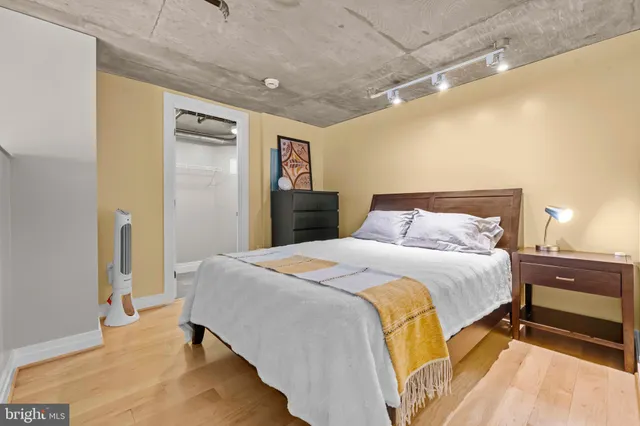 a bedroom with a bed and wooden floor