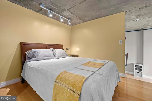 a bedroom with a bed and a flat tv screen on a dresser