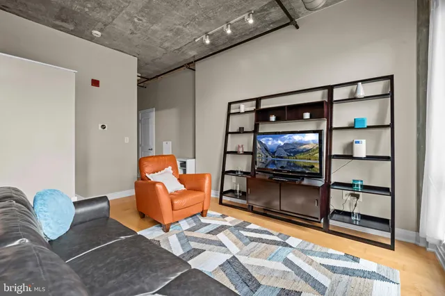 a living room with furniture a rug and white walls