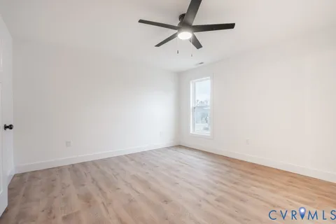 an empty room with a window and a fan