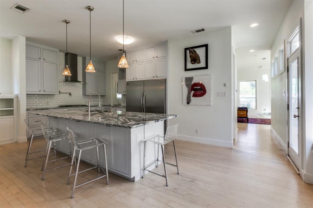 4206 Manning Lane Dallas, TX 75220 - Photo 13 of 35 a kitchen with kitchen island a dining table chairs cabinets and stainless steel appliances