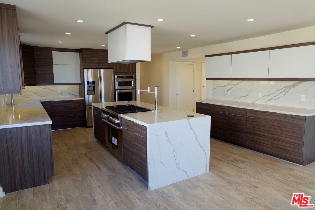 2 Catamaran Street, Unit 2 Marina del Rey, CA 90292 - Photo 4 of 17 a kitchen with stainless steel appliances kitchen island granite countertop a stove a refrigerator and a oven