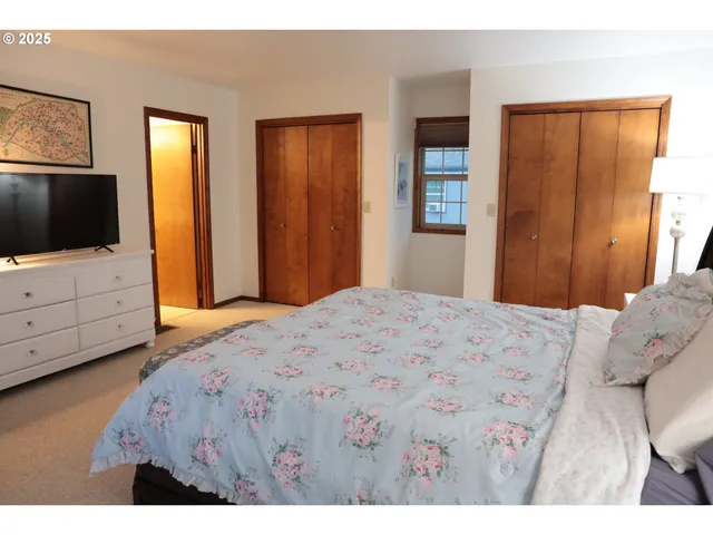 a bedroom with a bed and flat screen tv