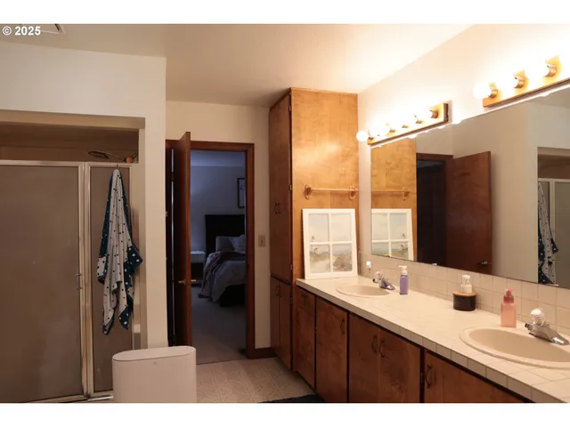a en suite bathroom with a double vanity sink a mirror and a bathtub