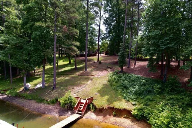 an aerial view of a house with a yard lake and outdoor seating