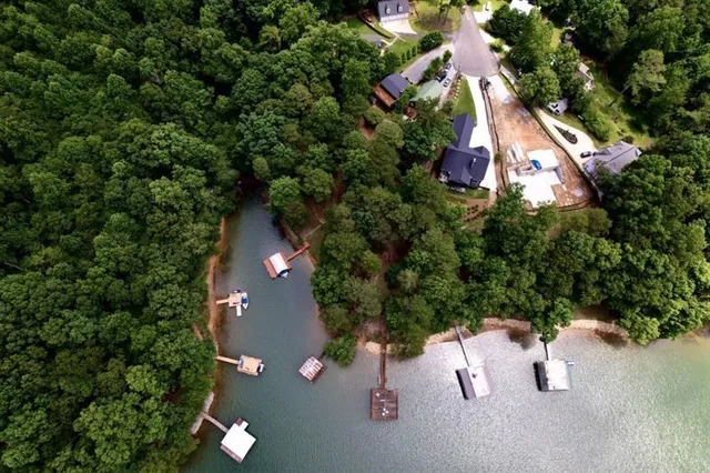 an aerial view of a house with a yard and trees all around