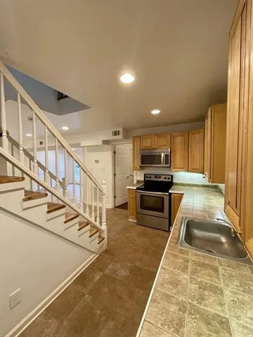 a kitchen with stainless steel appliances granite countertop a refrigerator and a stove