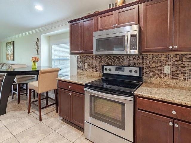 9446 Windrift Circle Fort Pierce, FL 34945 - Photo 2 of 13 a kitchen with granite countertop a stove top oven microwave and cabinets
