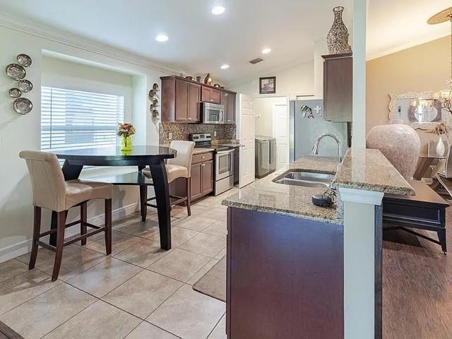 9446 Windrift Circle Fort Pierce, FL 34945 - Photo 3 of 13 a living room with stainless steel appliances kitchen island granite countertop furniture and a kitchen view