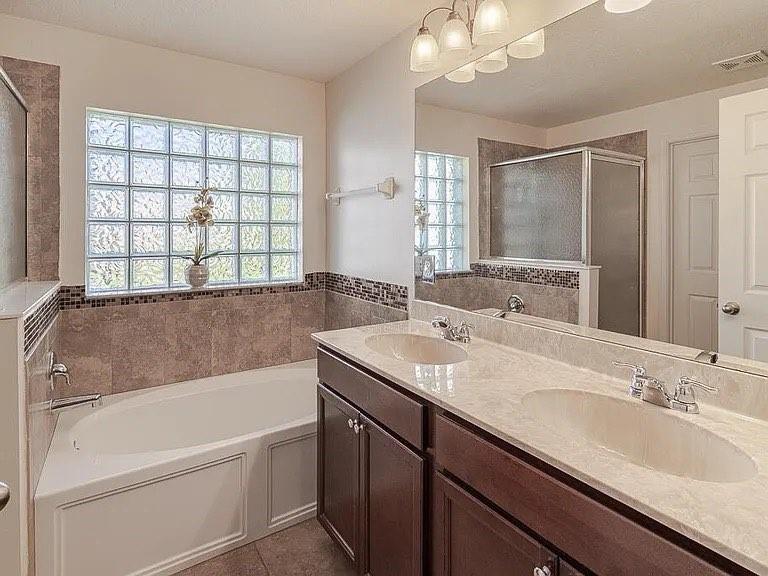 9446 Windrift Circle Fort Pierce, FL 34945 - Photo 9 of 13 a bathroom with a granite countertop sink mirror and a bathtub