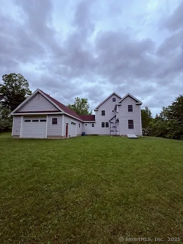 a view of a big house with a big yard and large trees