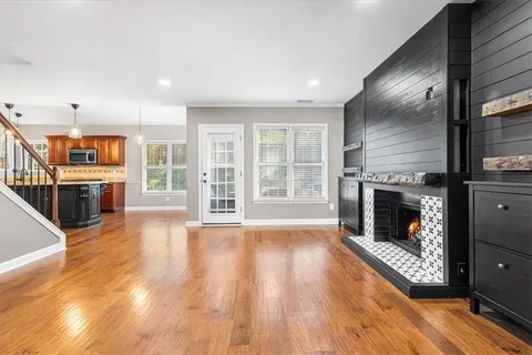 a view of a livingroom with wooden floor and a fireplace