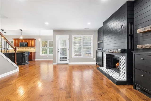 a view of a livingroom with wooden floor and a fireplace