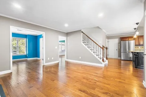a view of an empty room with wooden floor
