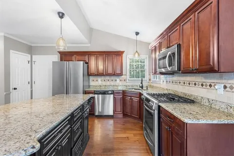 a kitchen with stainless steel appliances granite countertop a sink stove microwave and refrigerator