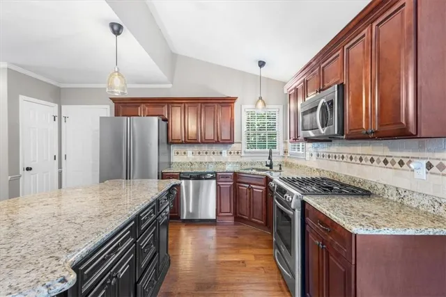 a kitchen with stainless steel appliances granite countertop a sink stove microwave and refrigerator