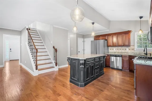 a kitchen with stainless steel appliances a stove cabinets and wooden floor