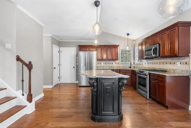 a kitchen with stainless steel appliances granite countertop a stove a sink dishwasher a refrigerator and a microwave oven