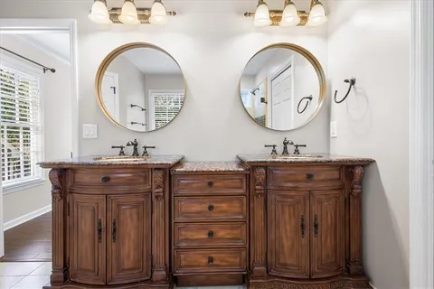 a bathroom with a granite countertop double vanity sink and a mirror