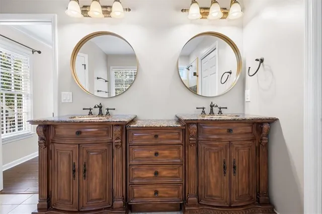 a bathroom with a granite countertop double vanity sink and a mirror