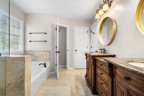 a bathroom with a granite countertop sink a mirror and a bathtub