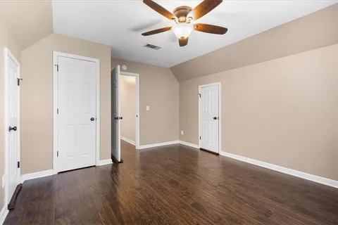 an empty room with wooden floor chandelier fan and closet area