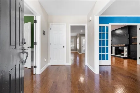 a view of a hallway with wooden floor and windows