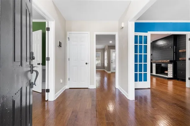 a view of a hallway with wooden floor and windows