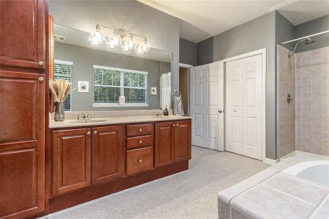a spacious bathroom with a granite countertop sink mirror and a shower