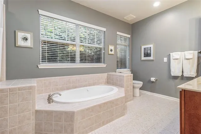 a bathroom with a tub a toilet a sink and a window