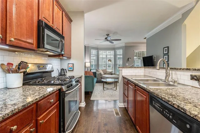 a kitchen with stainless steel appliances granite countertop a sink stove and cabinets