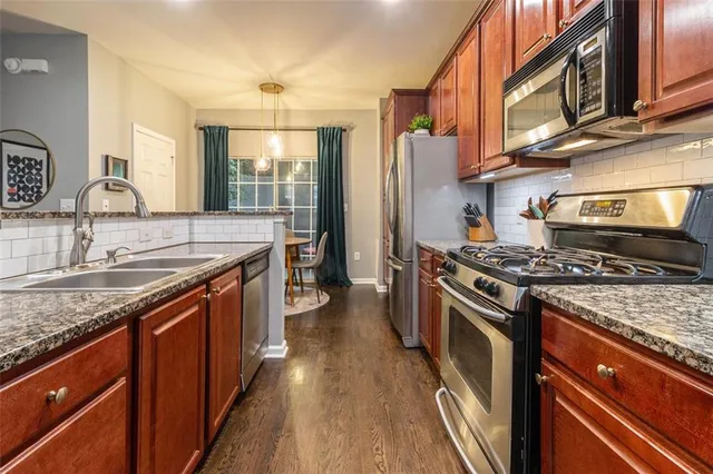 a kitchen with stainless steel appliances granite countertop a stove and a sink