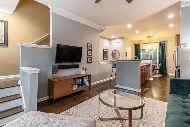 a living room with furniture a flat screen tv and kitchen view
