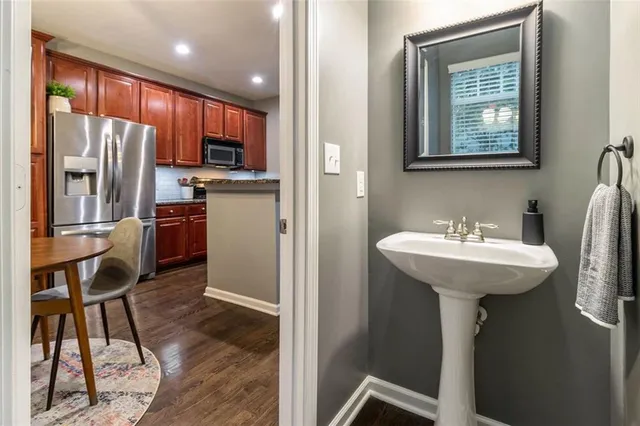 a kitchen with stainless steel appliances a sink cabinets and wooden floor