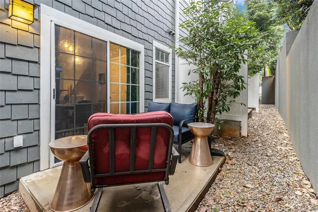 a view of a balcony with chairs and a potted plant