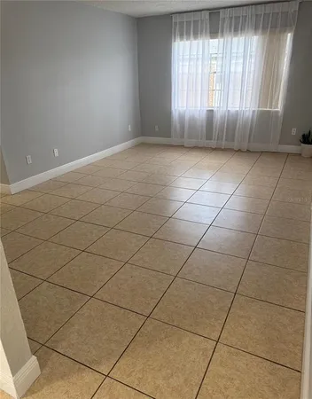 a view of a livingroom with an empty space and a window