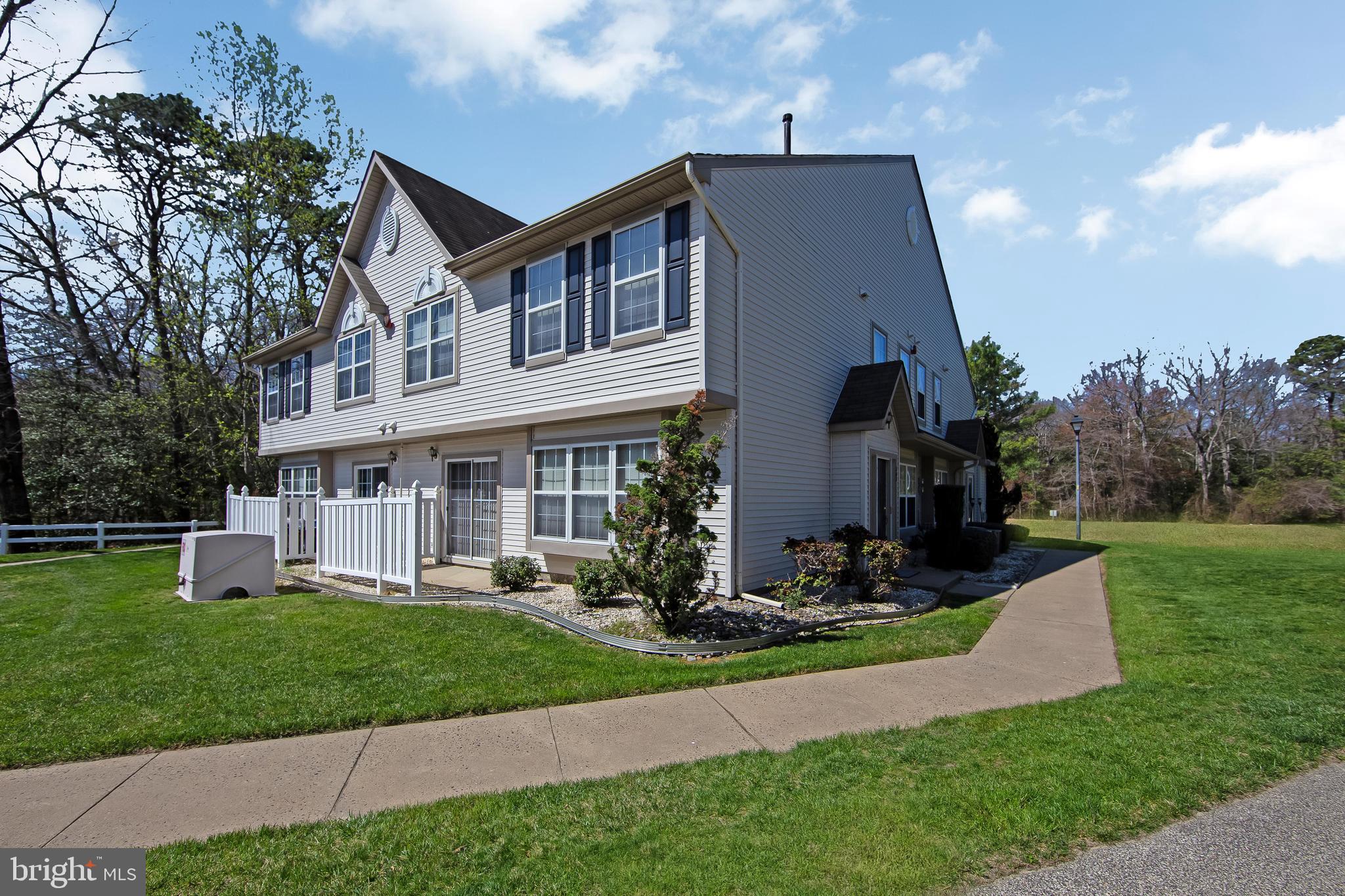 a front view of a house with garden and trees