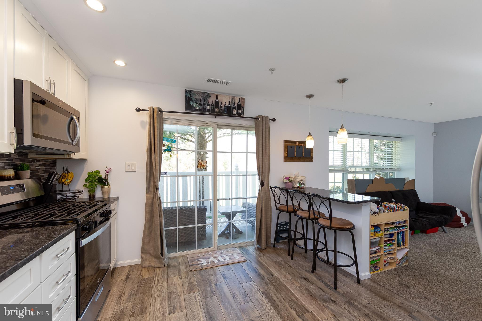 803 Tanglewood Drive Sicklerville, NJ 08081 - Photo 12 of 34 a kitchen with stainless steel appliances granite countertop a stove top oven a sink dishwasher and wooden cabinets with wooden floor