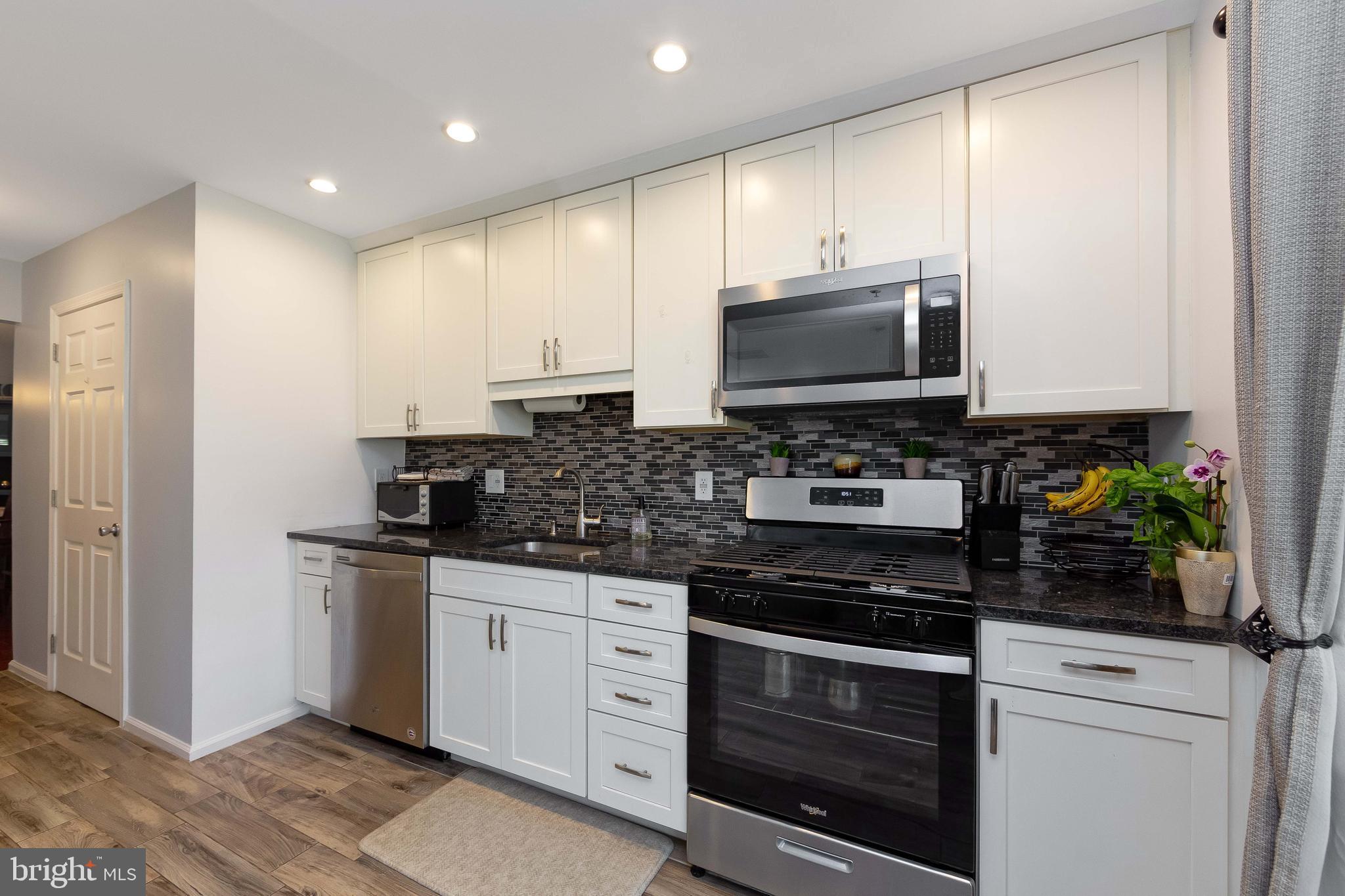 803 Tanglewood Drive Sicklerville, NJ 08081 - Photo 13 of 34 a kitchen with stainless steel appliances a stove a microwave a sink and cabinets