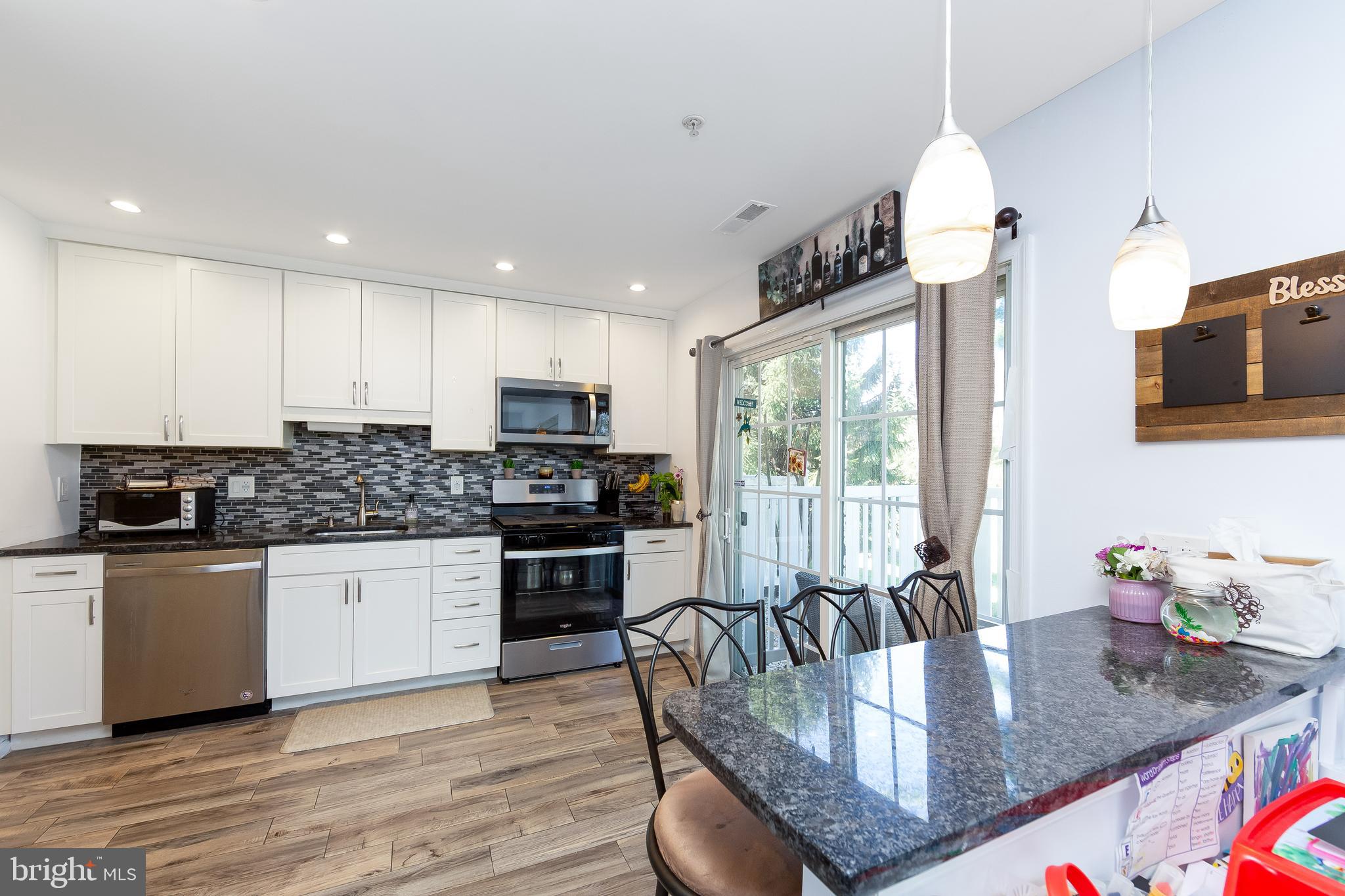 803 Tanglewood Drive Sicklerville, NJ 08081 - Photo 10 of 34 a kitchen with stainless steel appliances granite countertop a sink refrigerator dining table and chairs