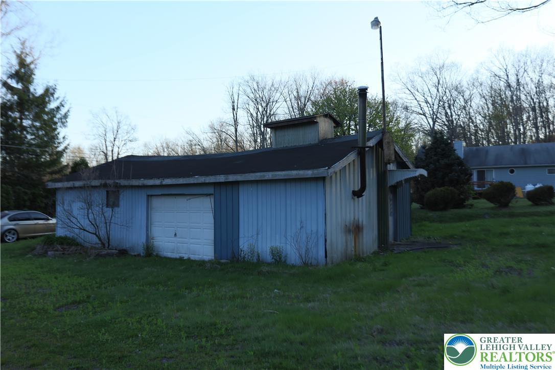 5444 Quakake Road Weatherly, PA 18255 - Photo 13 of 21 A detached shed with a garage door provides practical outdoor storage.