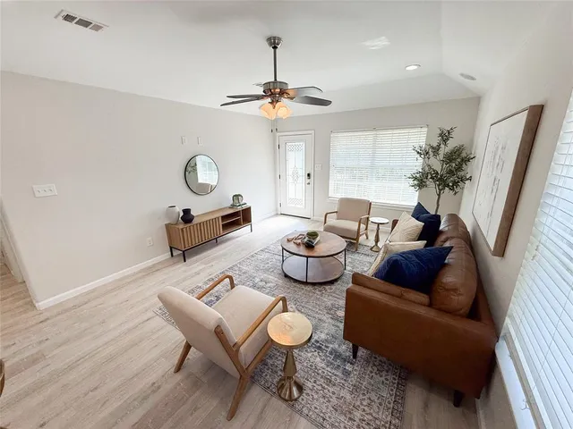 a living room with furniture a rug and a window