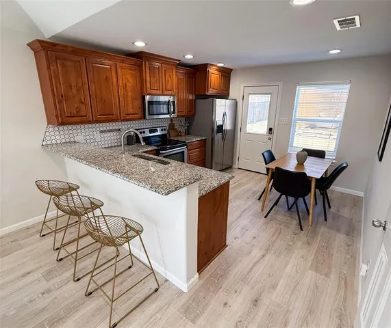 a kitchen with granite countertop wooden floors furniture and a window